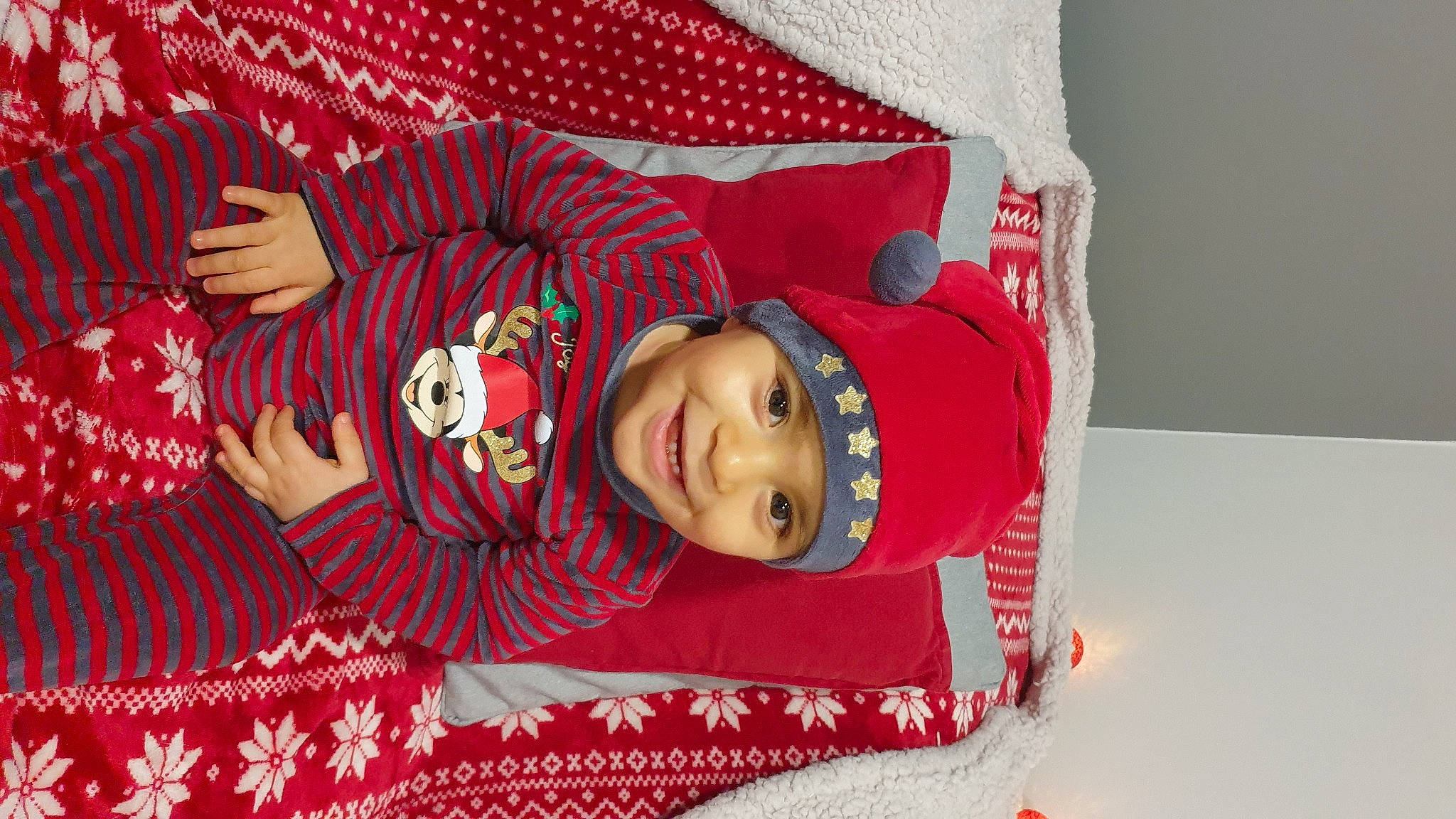 Noah participe au concours pour gagner de l'argent avec cette photo : baby, baby_toddler_clothing, carmine, child, christmas, christmas_eve, event, facial_expression, fictional_character, fun, happy, hat, headwear, holiday, joy, linens, pattern, person, pink, red