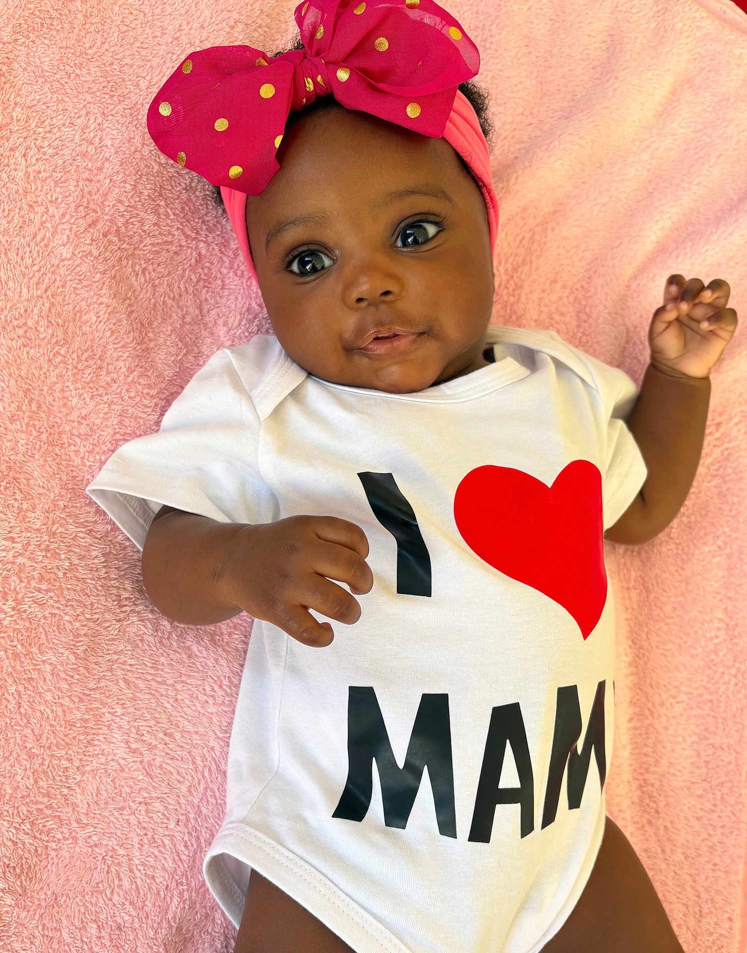 Chimfumnanya Or Naya is registered to the contest to win money with this photo: baby, infant, child, pink_blanket, onesie, headband, bow, polka_dots, love_message, cute, portrait, smiling, happy, laying_down, closeup, soft_texture, adorable, toddler, skin, hand