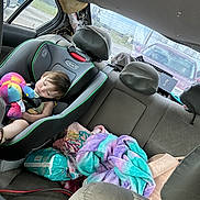 Aurora is registered to the contest to win money with this photo: backseat, blanket, car_interior, car_seat, child, child_safety, colorful, diapers, headrest, nap, plush_toy, rest, road, seatbelt, sleeping, stuffed_toy, toddler, travel, vehicle, window