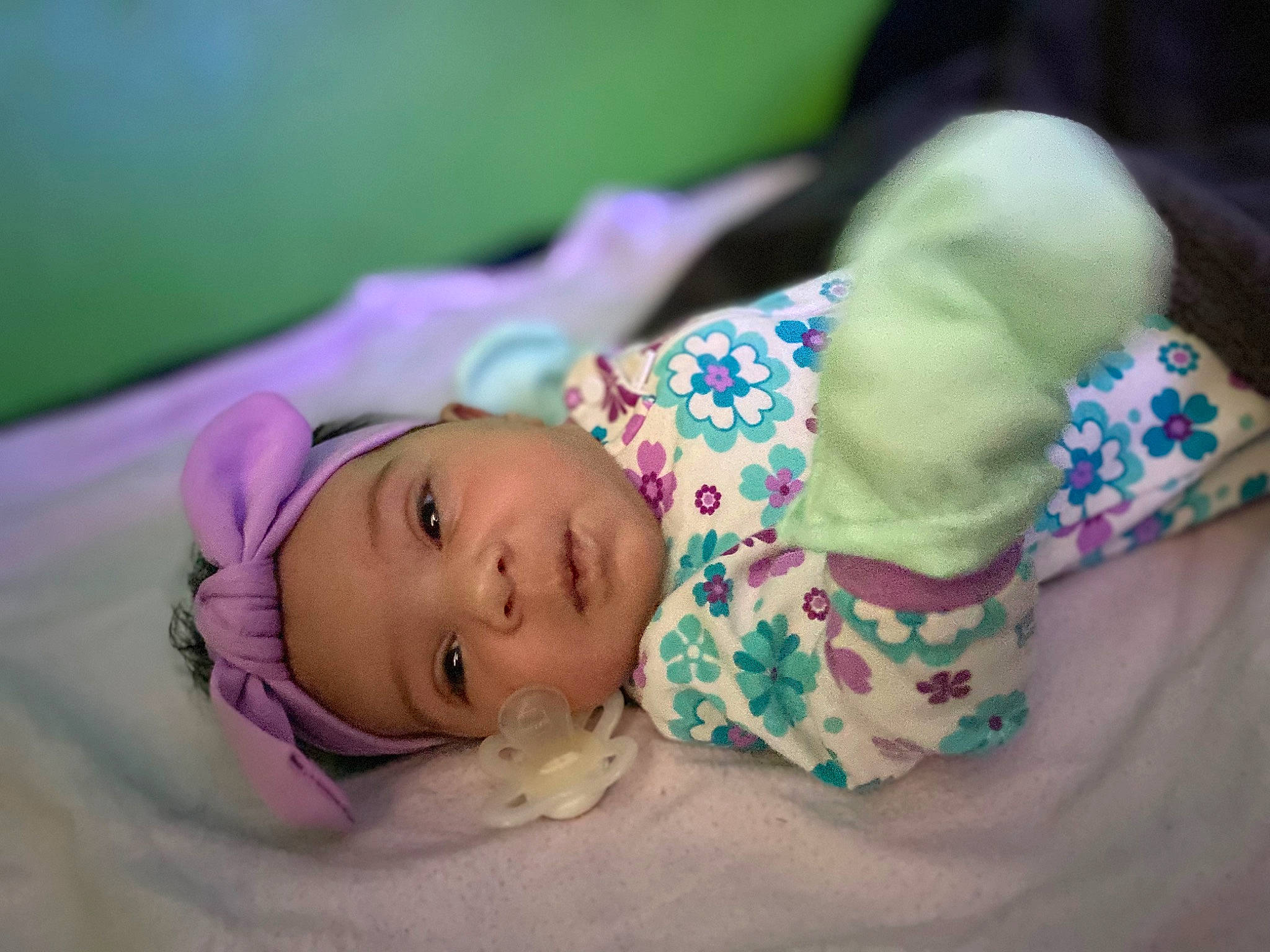 Maya is registered to the contest to win money with this photo: baby, baby_products, baby_toddler_clothing, bedtime, cheek, child, comfort, face, grass, headwear, linens, magenta, nap, person, portrait_photography, purple, room, sitting, skin, sleep