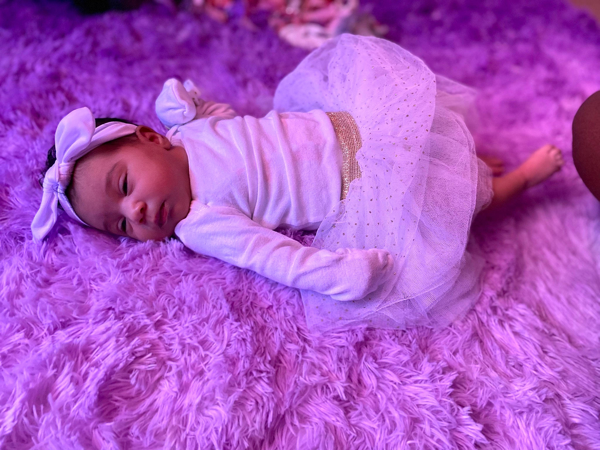 Maya is registered to the contest to win money with this photo: baby, baby_toddler_clothing, beanie, child, comfort, eye, face, fur, grass, happy, headgear, knit_cap, linens, magenta, person, pink, plant, purple, sleeve, toddler