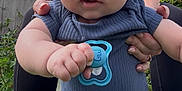 Damién is registered to the contest to win money with this photo: baby, child, pacifier, blue_shirt, denim_jeans, outdoor, garden, fence, plants, adult_hands, grass, sky, clouds, person, holding, cute, infant, portrait, casual_clothing, supporting