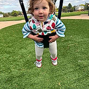 Cattleya joined the competition — help win amazing prizes! casual_clothing, child, curly_hair, daylight, fun, grass, happy, holding, jacket, nature, outdoor, park, person, play, playground, shoes, smile, swing, toddler, white_leggings