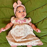 Reagan is registered to the contest to win money with this photo: baby, infant, child, dress, headband, bow, pink, green, quilt, blanket, cute, portrait, lying_down, hands, legs, face, eyes, expression, clothing, indoors