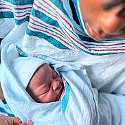 Asaya Love joined the competition — help win amazing prizes! newborn, baby, blanket, hospital, person, face, mask, hand, wrapped, sleeping, infant, closeup, soft, tender, parent, care, cloth, striped_blanket, skin, portrait