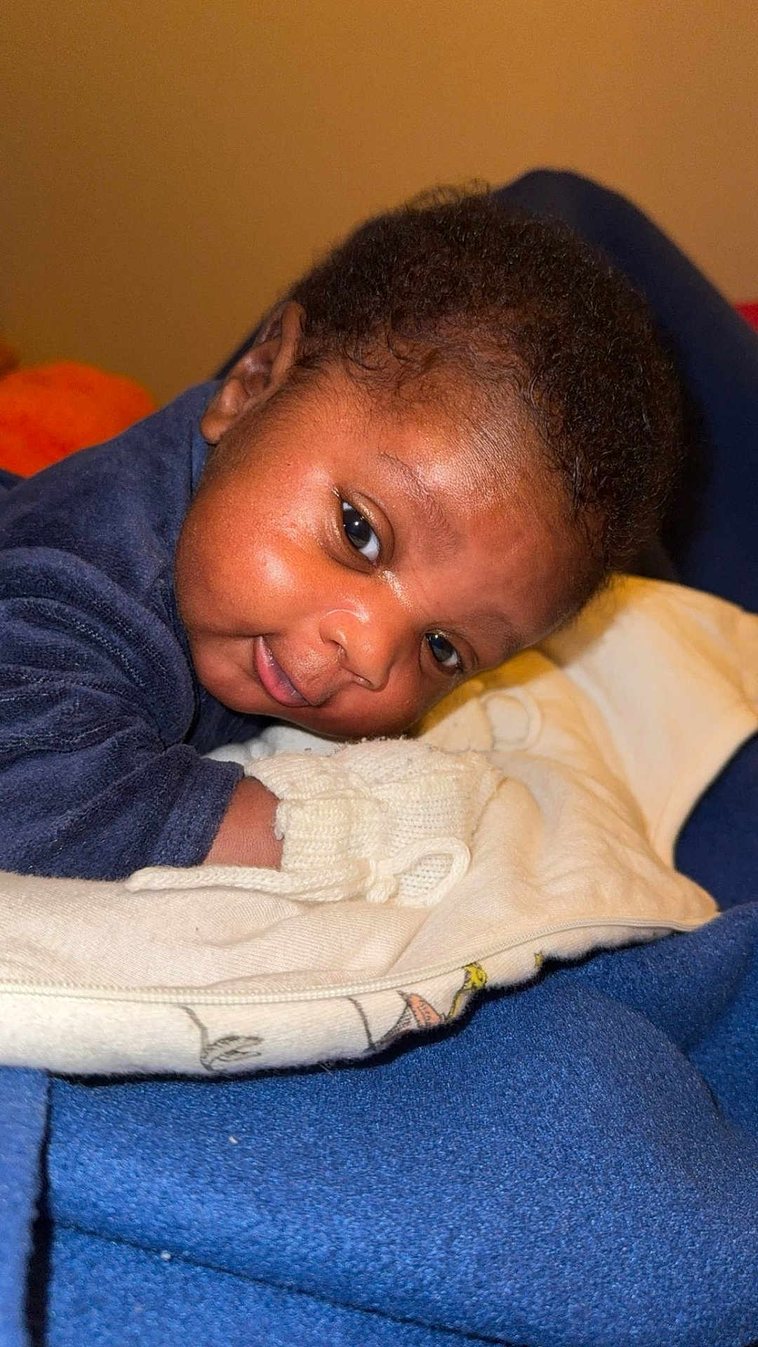 Jean Uriel a rejoint le concours — aidez-le/la à gagner de superbes lots ! baby, infant, child, face, smile, blanket, mittens, clothing, blue, warm, cozy, indoor, portrait, cute, young, lying_down, curious, soft_texture, closeup, person