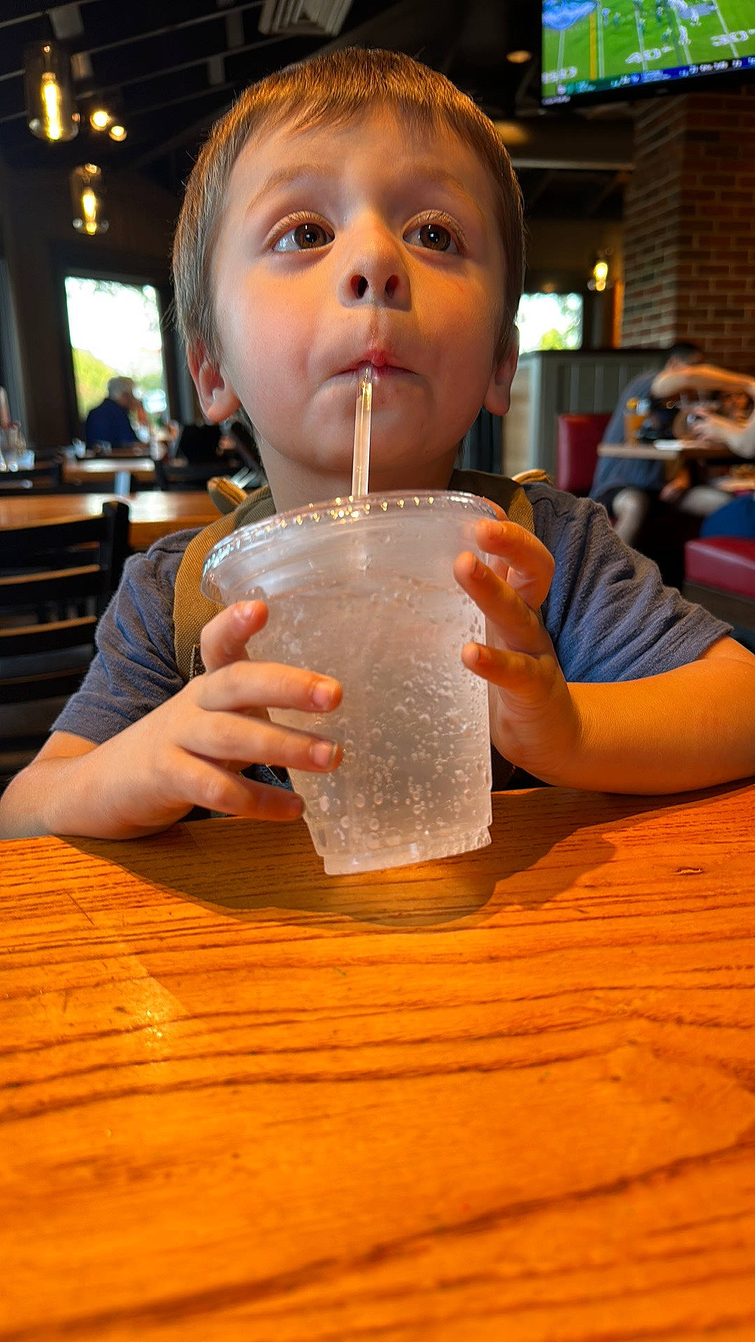 Brennan is registered to the contest to win money with this photo: alcohol, alcoholic_beverage, buttermilk, child, distilled_beverage, drink, drinking, drinking_straw, drinkware, fluid, fun, glass, hairstyle, hardwood, leisure, liquid, nail, person, table, toddler