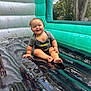 toddler, child, smiling, wet, inflatable, bounce_house, playful, outdoor, summer, fun, happy, reflection, greenery, shirt, barefoot, sitting, water, mesh_window, plastic, inflatable_floor