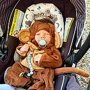 Ryker joined the competition — help win amazing prizes! baby, infant, child, stroller, monkey_costume, animal_costume, pacifier, sitting, buckled_in, brown_clothing, hat, tail, toy, baby_carrier, outdoor, pebbles, portrait, face, playful, family_photo