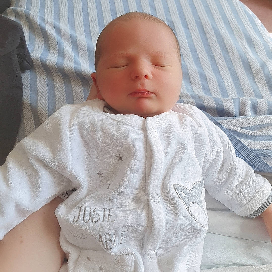 César a rejoint le concours — aidez-le/la à gagner de superbes lots ! baby, baby_products, baby_sleeping, baby_toddler_clothing, bedding, cheek, child, collar, comfort, linens, neck, pattern, person, sitting, skin, sleeve, t_shirt, textile, toddler, wool