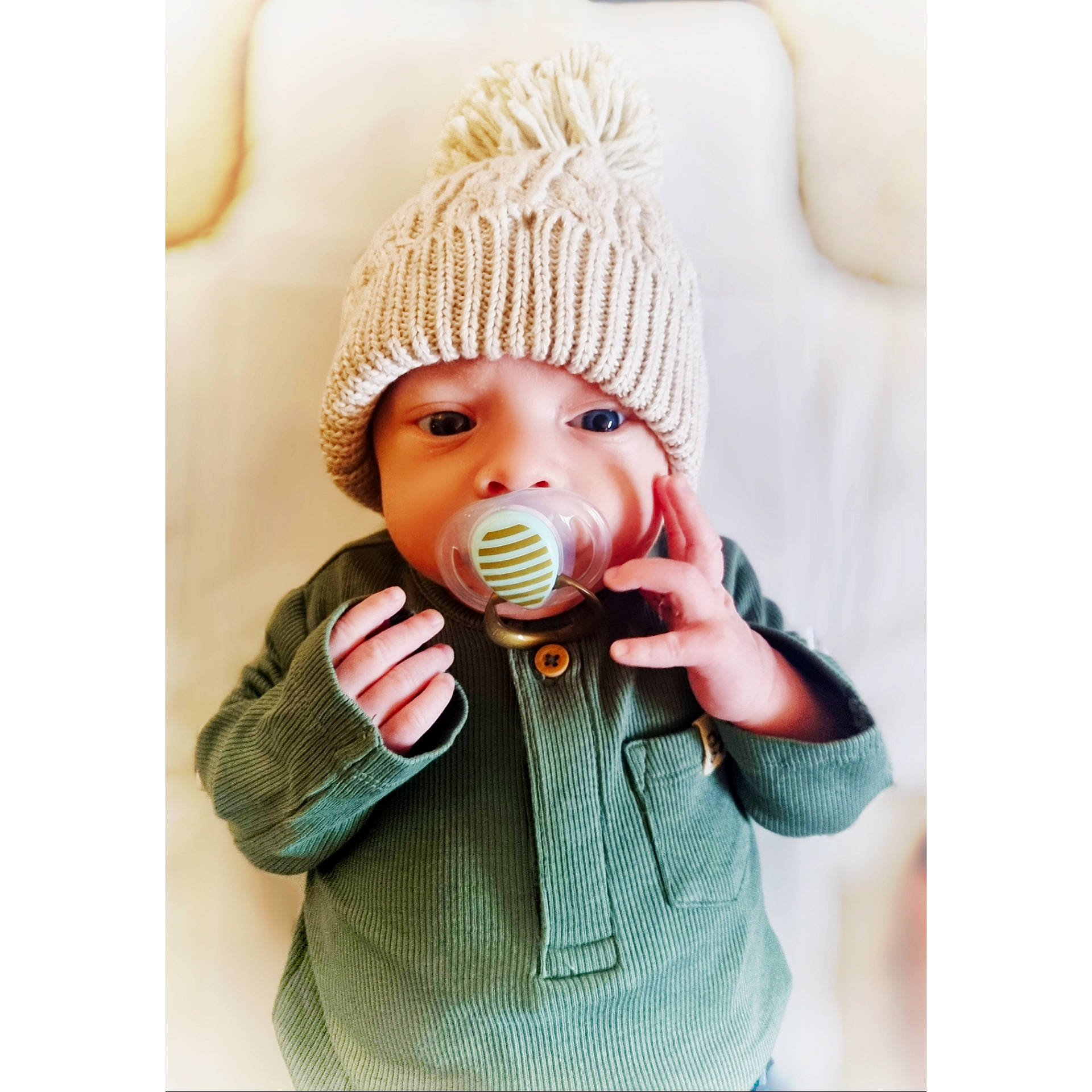 Zach is registered to the contest to win money with this photo: baby, baby_toddler_clothing, beanie, cap, clothing, collar, costume_hat, gesture, headwear, knit_cap, magenta, neck, outerwear, pattern, person, shirt, sleeve, t_shirt, thumb, toddler
