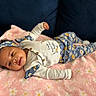 Anova is registered to the contest to win money with this photo: baby, infant, smiling, lying_down, blanket, floral_pattern, headband, clothing, cute, happy, indoors, soft_texture, pink, yellow, white, cozy, portrait, child, toddler, relaxed