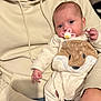 baby, infant, pacifier, onesie, animal_print, adult, hoodie, casual_clothing, indoor, closeup, holding, cute, soft_lighting, portrait, human, child, comfort, warm, skin, face