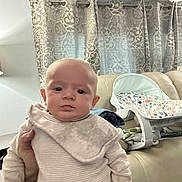 Declan joined the competition — help win amazing prizes! baby, indoor, curtains, sofa, baby_rocker, person, clothing, hand, face, head, infant, pattern, fabric, home, furniture, cute, newborn, sitting, human, room