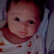 Levi joined the competition — help win amazing prizes! baby, infant, onesie, stars, planets, space_theme, face, eyes, cute, portrait, sleepwear, dark_background, twinkle_effect, newborn, child, expression, indoors, soft_lighting, head, small