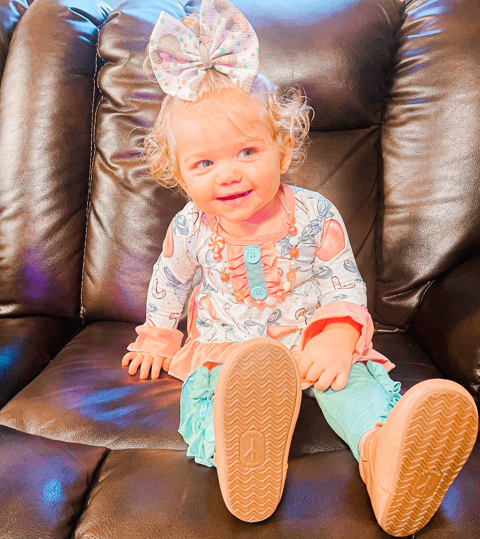 Paizley is registered to the contest to win money with this photo: baby_toddler_clothing, child, comfort, cool, couch, facial_expression, fun, furniture, happy, human_body, joy, leg, leisure, magenta, organ, person, pink, skin, smile, textile