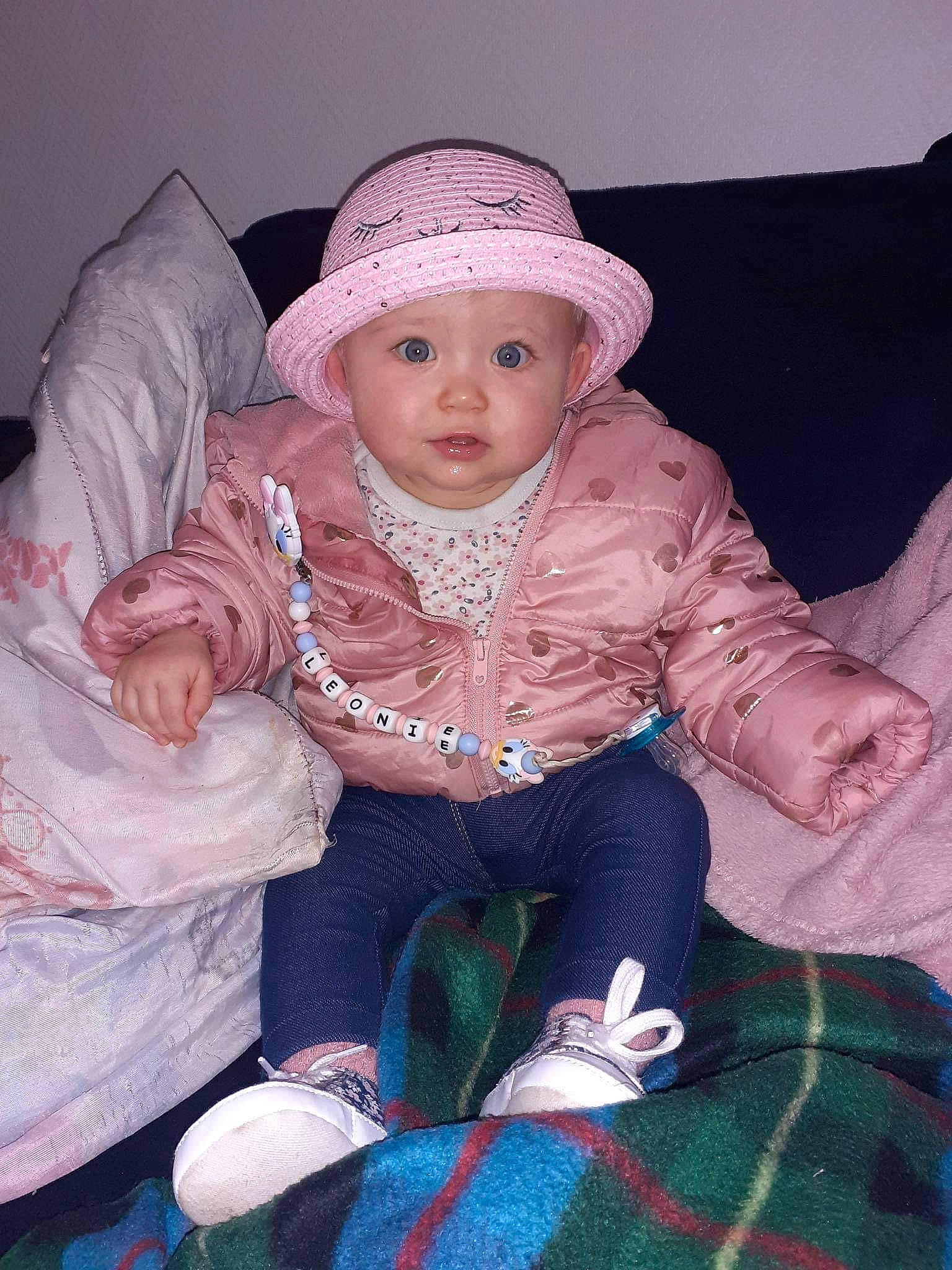 Léonie participe au concours pour gagner de l'argent avec cette photo : baby, baby_toddler_clothing, cap, cheek, child, comfort, costume_hat, eye, fashion_accessory, hat, headwear, human_body, iris, pattern, person, plaid, sitting, skin, sleeve, tartan
