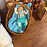 baby, basket, blanket, blue_clothing, bow_tie, wooden_floor, flower_pots, flowers, indoor, sleeping, cute, infant, easter, toddler, cozy, wicker, soft_texture, peaceful, decor, footwear