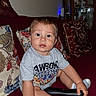 Azriel is registered to the contest to win money with this photo: baby, child, toddler, sitting, couch, sofa, pillow, indoor, portrait, face, eyes, wide_eyed, short_hair, smiling, clothing, t_shirt, socks, toy, handle, home_decor
