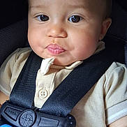 Azriel is registered to the contest to win money with this photo: baby, child, infant, car_seat, seat_belt, buckled, portrait, close_up, face, eyes, pout, serious_expression, sitting, indoors, vehicle, travel, clothing, shirt, blue_cord, photograph