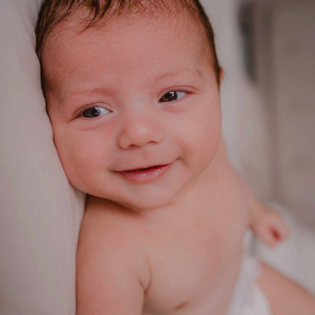 Ezio a rejoint le concours — aidez-le/la à gagner de superbes lots ! baby, bare_skin, close_up, comfort, cushion, cute, diaper, expression, eyes, face, head, indoors, infant, mouth, person, portrait, skin, smile, soft_light, young_child