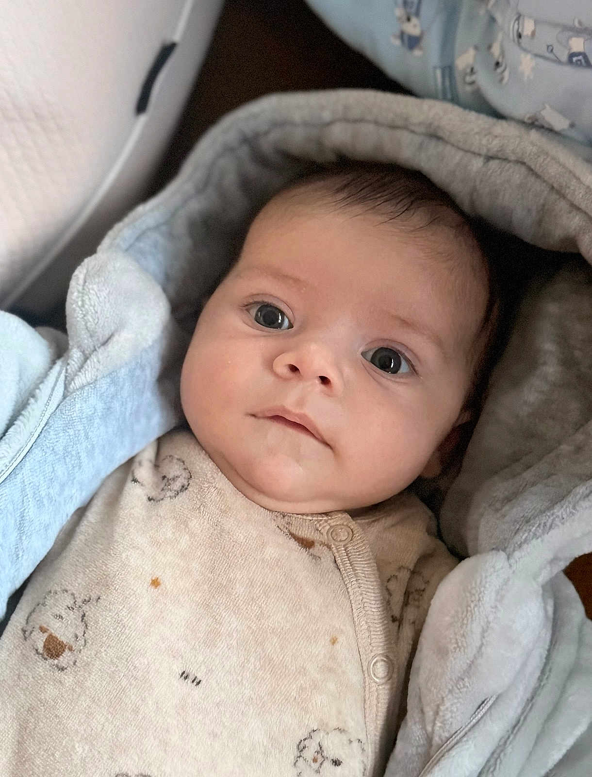 Lio participe au concours pour gagner de l'argent avec cette photo : baby, infant, child, face, eyes, blanket, hood, clothing, cute, portrait, soft, warm, newborn, expression, indoors, person, sleepwear, cozy, closeup, calm