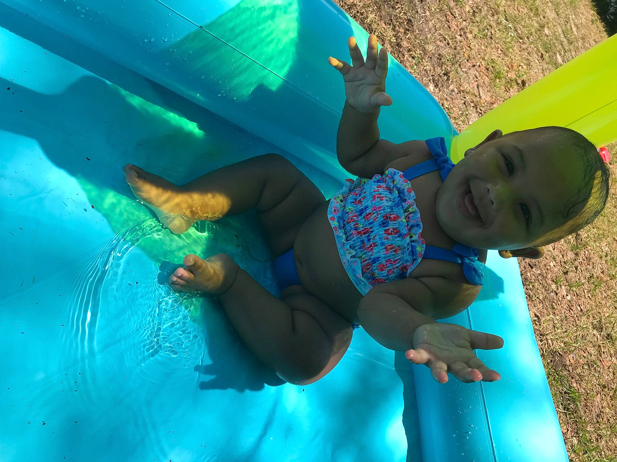 Audreyana is registered to the contest to win money with this photo: aqua, azure, baby, child, electric_blue, fun, grass, green, happy, joy, leg, leisure, organism, outdoor_play_equipment, people_in_nature, person, play, recreation, smile, toddler