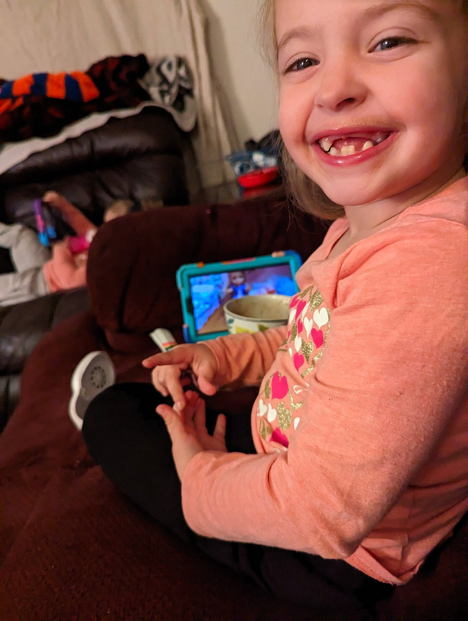 Kyndall is registered to the contest to win money with this photo: cheek, child, comfort, ear, electronic_device, event, finger, fun, gadget, happy, iris, joy, lap, mouth, person, shoulder, sitting, skin, smile, t_shirt