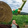 Briggs joined the competition — help win amazing prizes! baby, balloons, birthday, blanket, celebration, child, cloudy_sky, cornfield, farm, field, grass, green_balloon, hay_bale, infant, number_balloon, outdoor, overalls, portrait, sitting, striped_clothing