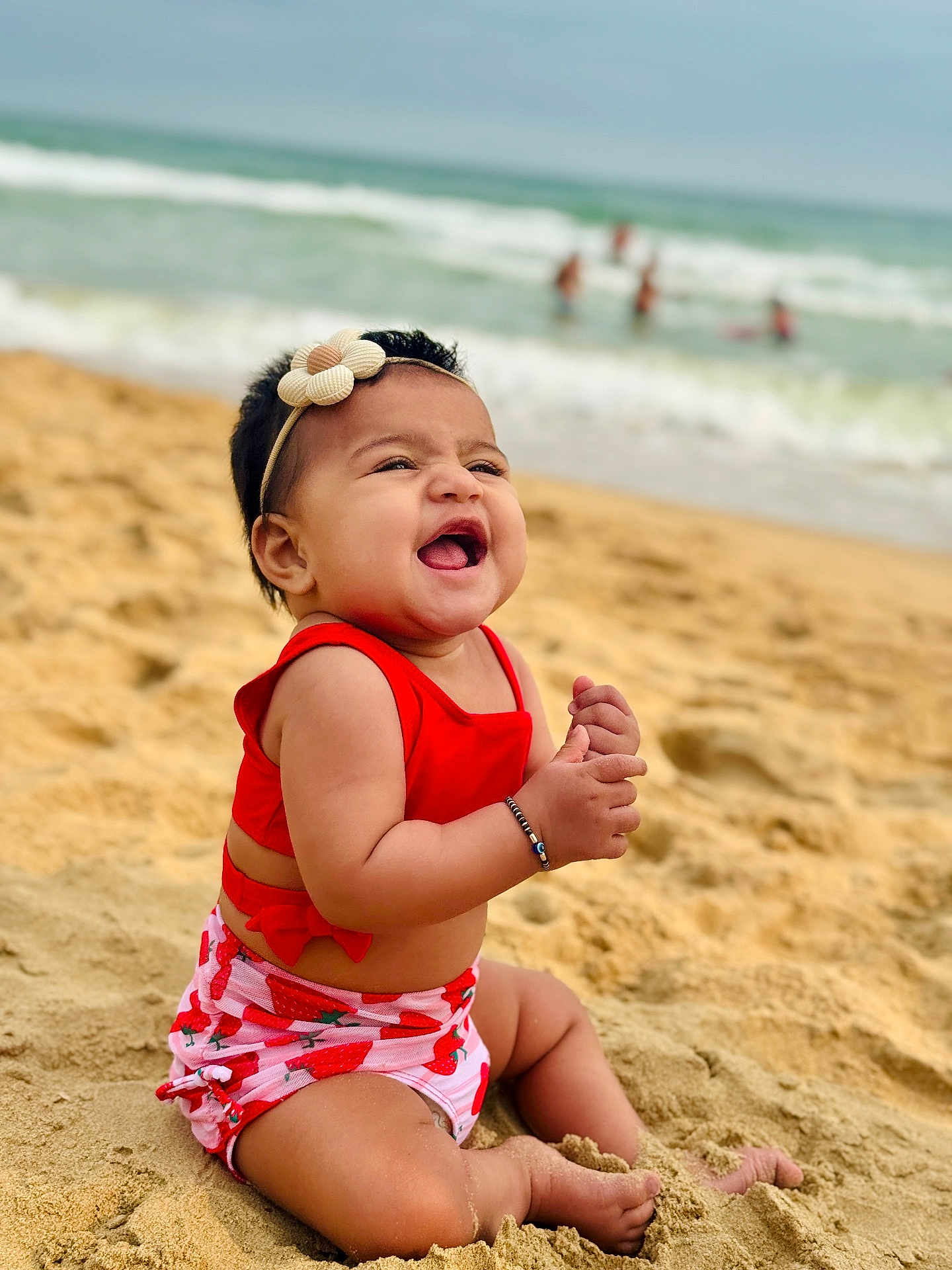 Prayah joined the competition — help win amazing prizes! baby, beach, sand, ocean, water, waves, smiling, child, headband, red_clothing, summer, vacation, happy, sitting, cute, outdoor, nature, sunny, playful, toddler