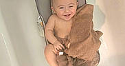 Caden is registered to the contest to win money with this photo: baby, bathtub, bath_seat, towel, smiling, winking, infant, happy, skin, bathroom, child, person, sitting, cute, water, home, clean, relaxing, indoors, playful