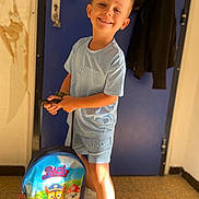 Ange a rejoint le concours — aidez-le/la à gagner de superbes lots ! backpack, blue_clothing, boy, casual, child, door, floor, footwear, hair, handle, happy, indoor, paw_patrol, person, playful, shorts, smile, standing, tshirt, young
