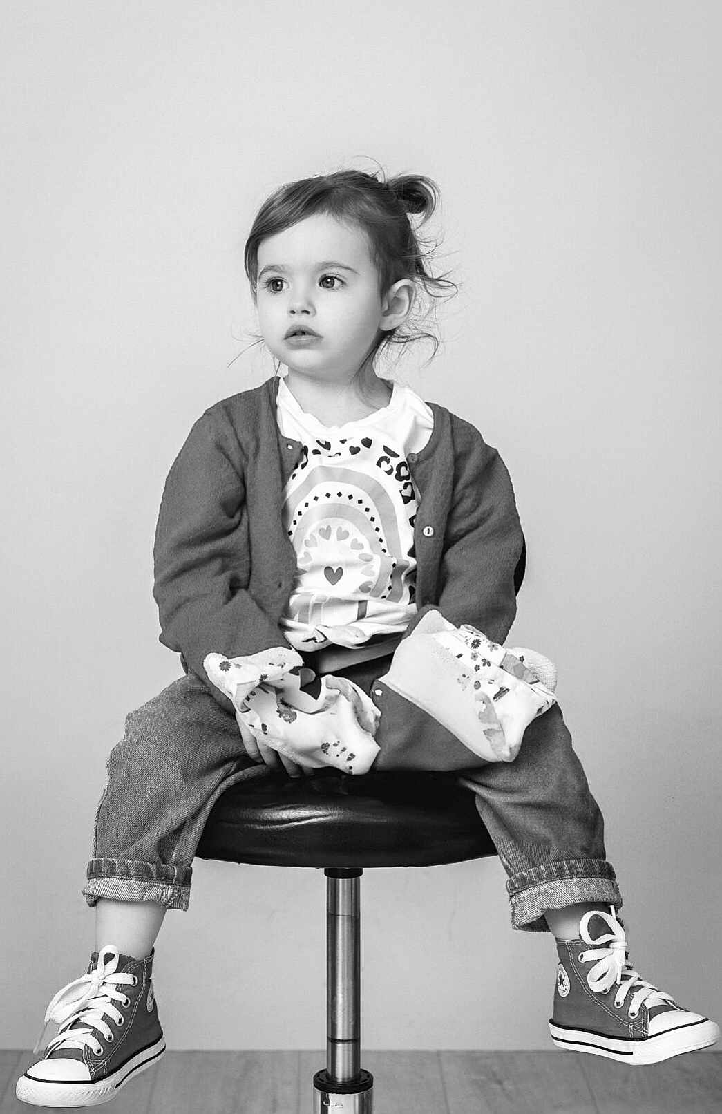 Clementine a rejoint le concours — aidez-le/la à gagner de superbes lots ! toddler, child, jeans, cardigan, sneakers, shirt, stool, black_and_white, portrait, indoor, curly_hair, casual_clothing, footwear, sitting, young_child, expression, curious, studio, fashion, cute