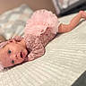 baby, infant, pink_clothing, lace, headband, tummy_down, blanket, bed, pillow, soft_texture, cute, newborn, lying_down, portrait, indoors, child, person, sleepwear, baby_girl, resting