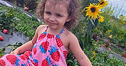Velenia is registered to the contest to win money with this photo: casual_clothing, child, curly_hair, daylight, field, flowers, garden, girl, greenery, growth, nature, outdoor, plants, playful, smiling, sneakers, strawberry_print, summer, sunflowers, vegetation