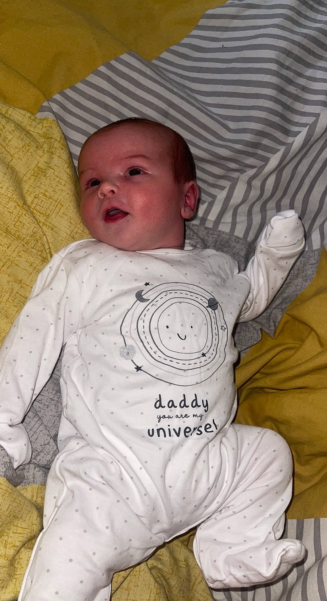 Jebson is registered to the contest to win money with this photo: baby, baby_toddler_clothing, cheek, child, chin, comfort, facial_expression, head, iris, linens, mouth, nose, organ, person, product, skin, sleeve, smile, t_shirt, textile