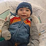Anthony joined the competition — help win amazing prizes! baby, smiling, beanie, jacket, colorful_clothing, blanket, cozy, infant, child, cute, patterned_blanket, warm, comfort, portrait, indoor, happy, person, sitting, clothing, face