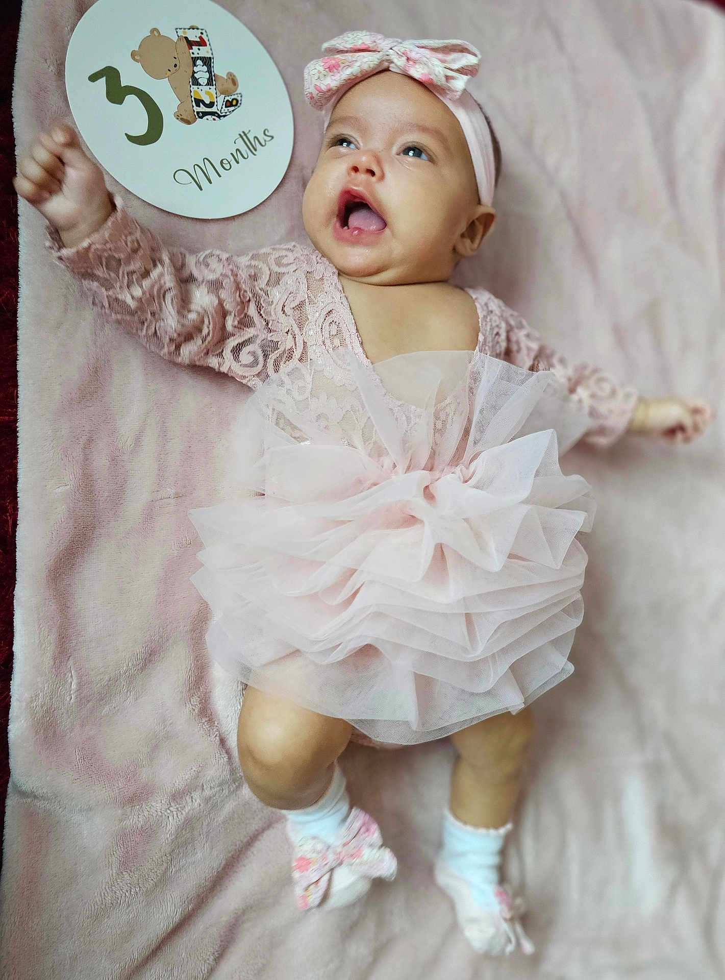 Heart is registered to the contest to win money with this photo: baby, infant, girl, pink_dress, headband, socks, milestone_card, 3_months, blanket, lying_down, smiling, happy, cute, celebration, soft_texture, tulle, lace, child, portrait, person