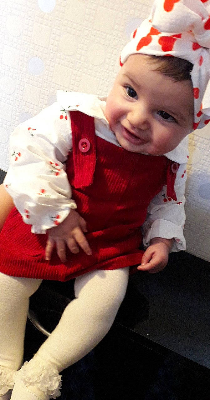 Molka Khaled participe au concours pour gagner de l'argent avec cette photo : baby, baby_products, baby_toddler_clothing, bonnet, carmine, cheek, child, christmas, costume, costume_accessory, costume_hat, fictional_character, headwear, human_body, lap, lip, person, red, sitting, sleeve