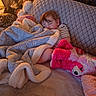 Waylon is registered to the contest to win money with this photo: child, toddler, sleeping, blanket, plush_toy, pink_toy, couch, pillow, striped_shirt, cozy, indoor, soft_toys, rest, nap, furniture, home, relaxation, comfort, cute, peaceful