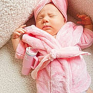 Maeve is registered to the contest to win money with this photo: baby, blanket, bodypart, bonnet, bottle, clothing, diaper, face, finger, furniture, hand, hat, head, newborn, person, photography, portrait, shaker, sleeping, towel