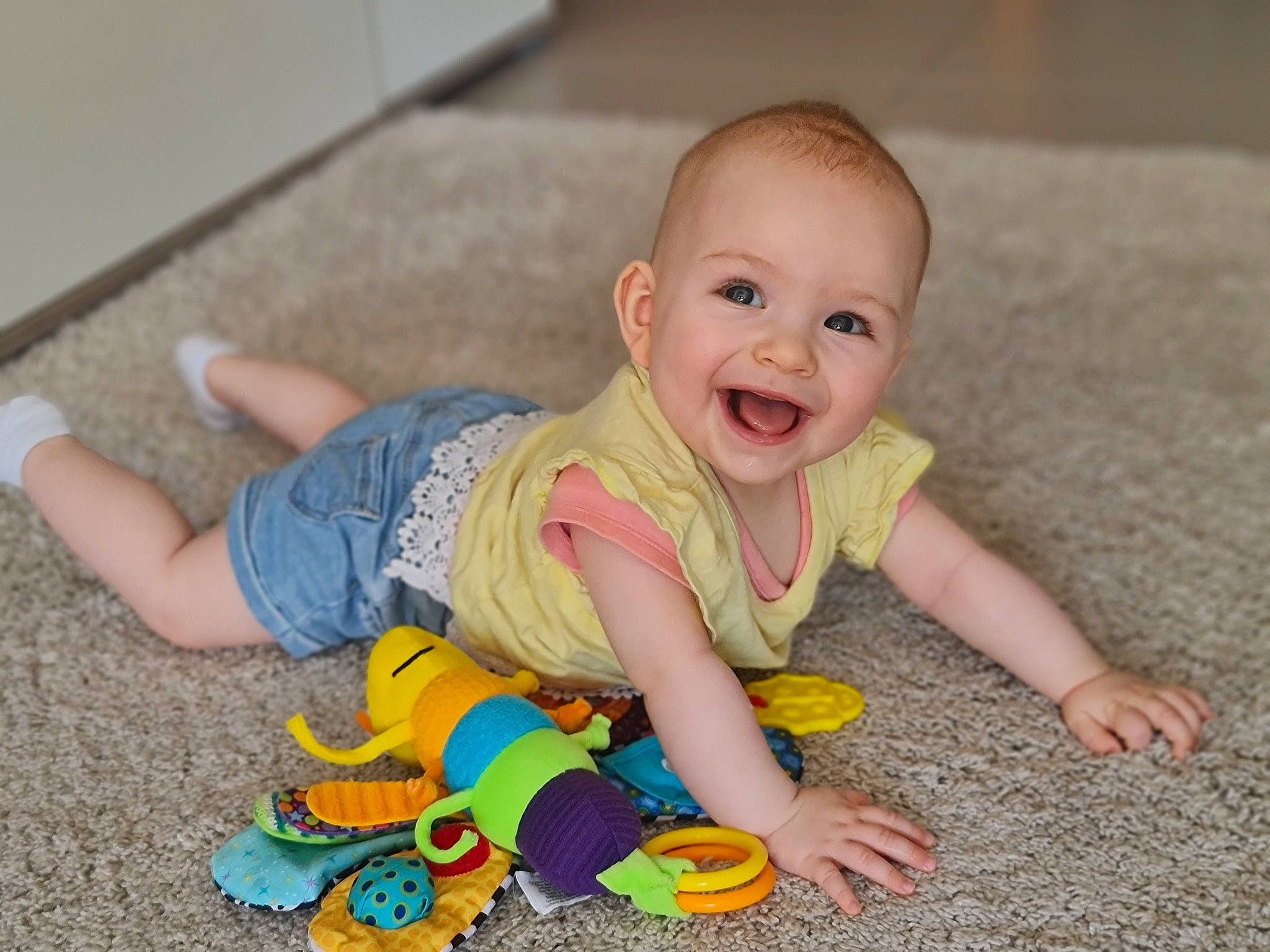 Iliana participe au concours pour gagner de l'argent avec cette photo : baby, baby_toddler_clothing, cheek, child, crawling, face, floor, flooring, foot, fun, happy, hardwood, joy, pattern, person, play, sitting, skin, sleeve, smile