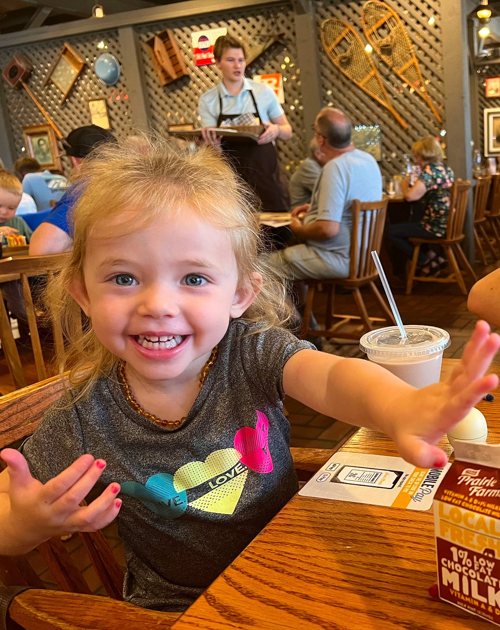 Austyn is registered to the contest to win money with this photo: chair, child, drink, eating, event, fun, happy, joy, laugh, leisure, party, person, recreation, smile, t_shirt, table, tableware, thumb, toddler, tree