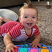 Kelce joined the competition — help win amazing prizes! baby, child, toy, piano, carpet, indoor, smiling, happy, playful, red_striped_clothing, hand, face, furniture, footwear, home, floor, head, expression, infant, colorful
