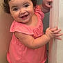 toddler, child, smiling, curly_hair, pink_dress, barefoot, door_frame, indoor, happy, cute, baby, person, skin, face, hand, foot, standing, portrait, young_child, expression