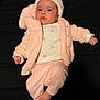 baby, infant, child, pink_clothing, hat, jacket, long_pants, foot, hand, face, lying_down, indoor, cute, warm_clothing, expression, portrait, person, soft_texture, cozy, newborn