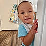 baby, child, toddler, face, portrait, peeking, curious, indoors, doorway, door_frame, hands, smiling, eyes, short_hair, blue_shirt, striped_clothing, hallway, wood_floor, home, photography