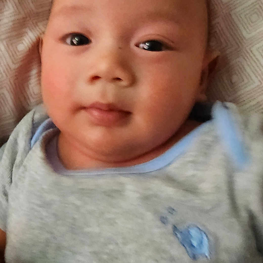 Kyle joined the competition — help win amazing prizes! baby, blanket, blue, child, closeup, clothing, cute, expression, eyes, face, grey, head, indoors, infant, laying, pattern, portrait, skin, soft, young