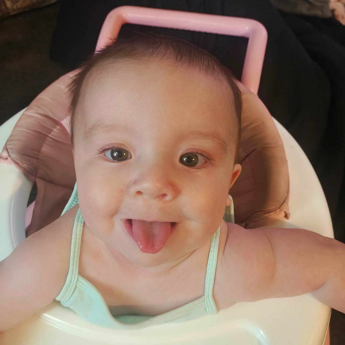 Tatyana is registered to the contest to win money with this photo: baby, child, clothing, cute, expression, face, happy, head, highchair, indoors, infant, person, pink, playful, seat, skin, smiling, tongue, tongue_out, young