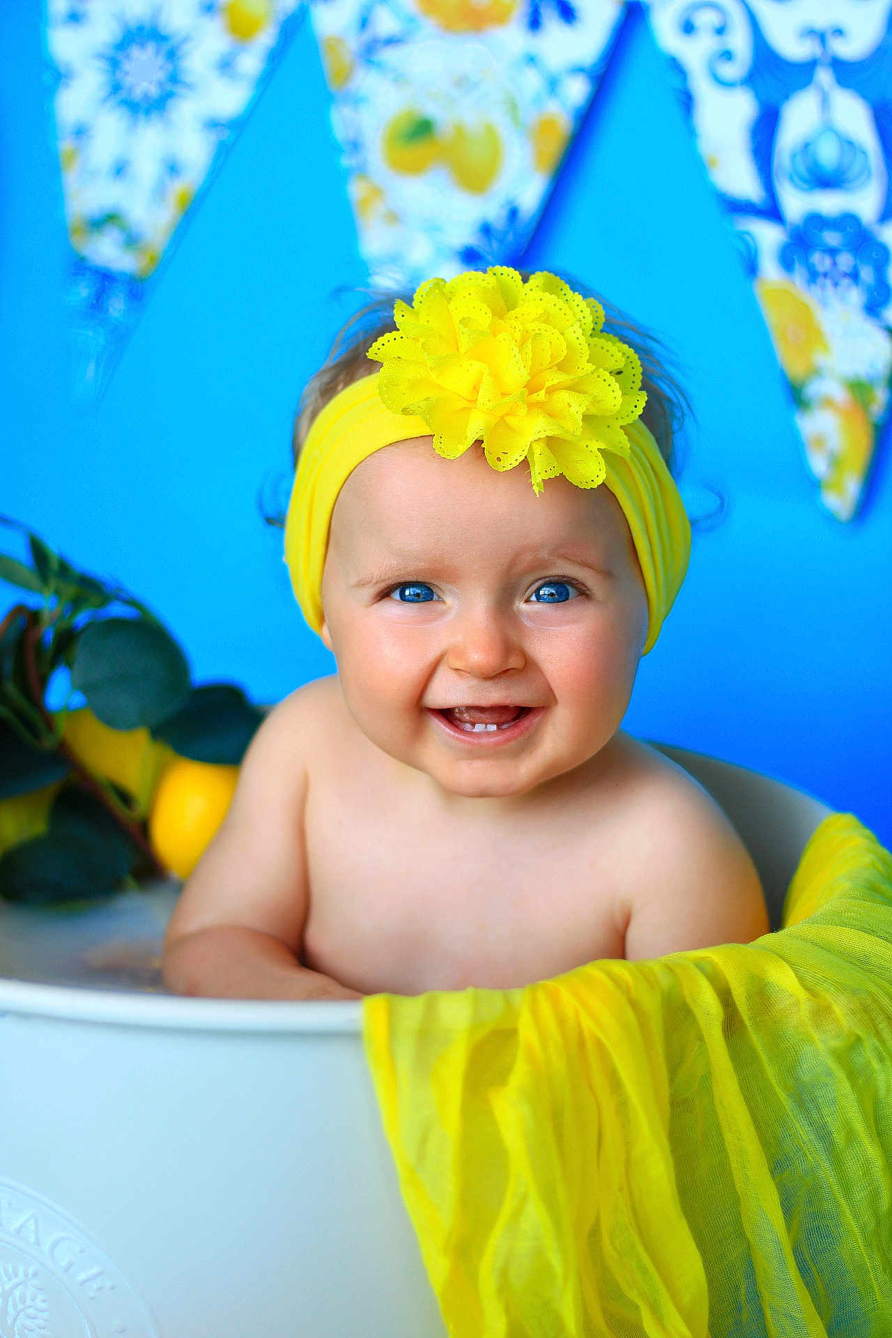 éva participe au concours pour gagner de l'argent avec cette photo : baby, smiling, blue_eyes, yellow_headband, flower, tub, blue_background, yellow_scarf, happy, child, portrait, indoor, cute, infant, colorful, decor, plant, fruit, fresh, cheerful